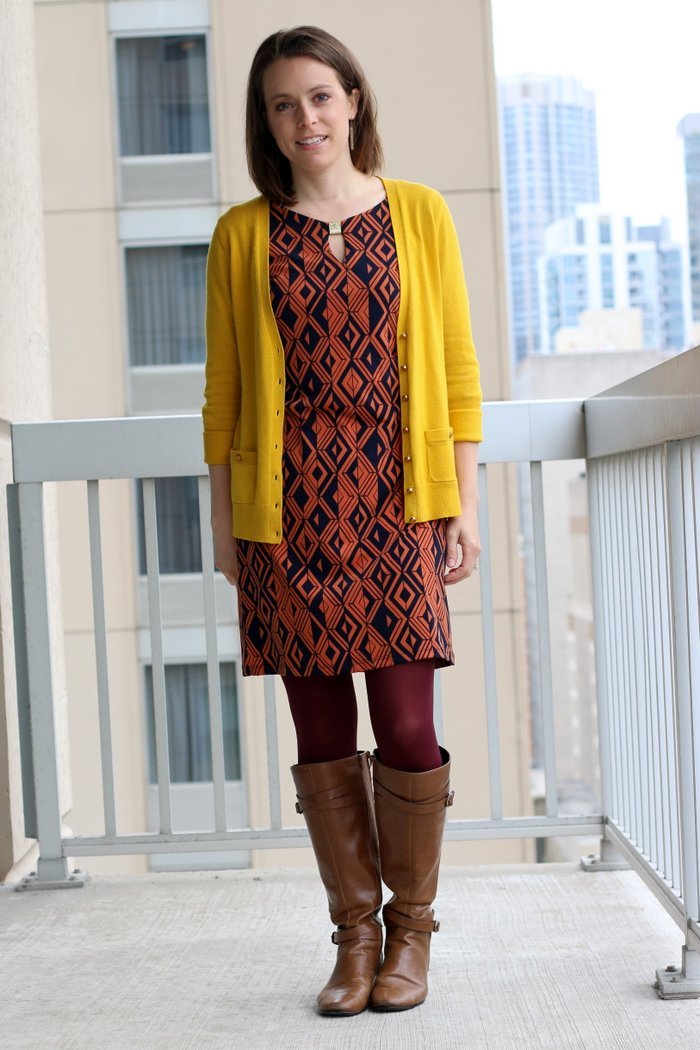 FashionablyEmployed.com | Orange and navy geometric print dress, maroon tights, mustard cardigan and cognac boots | wear to work outfit, office style, workwear