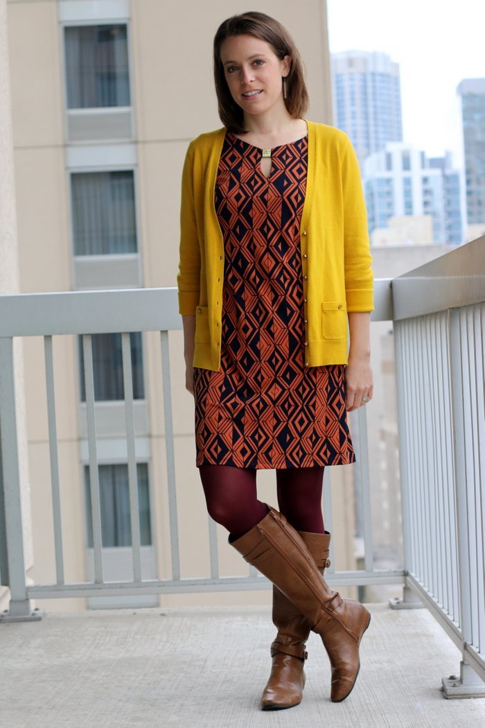 FashionablyEmployed.com | Orange and navy geometric print dress, maroon tights, mustard cardigan and cognac boots | wear to work outfit, office style, workwear