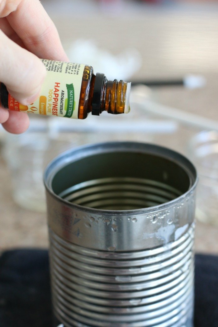 dropping essential oils into melted beeswax