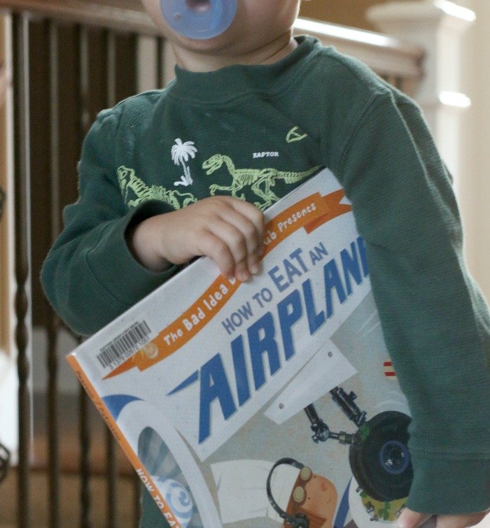 little-boy-holding-a-book-about-airplanes