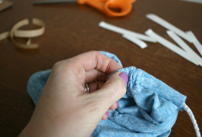 pushing-safety-pin-through-tube-to-thread-string-for-diy-bag