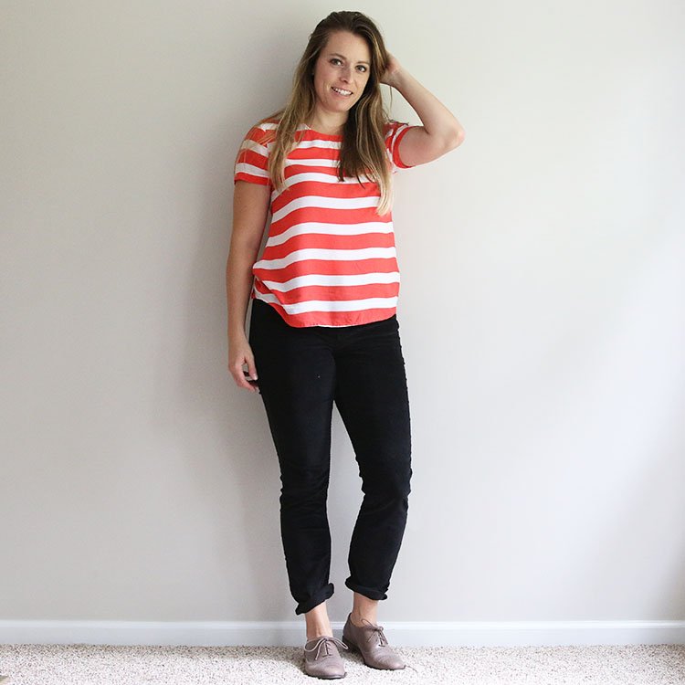 woman in orange and white striped shirt with black corduroy pants