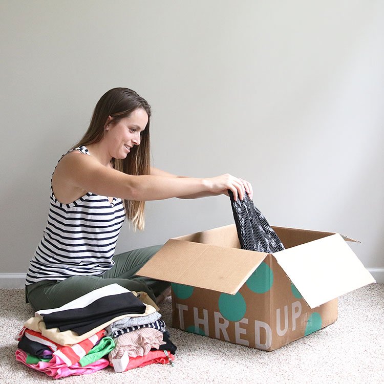 woman going through thredup Rescues box