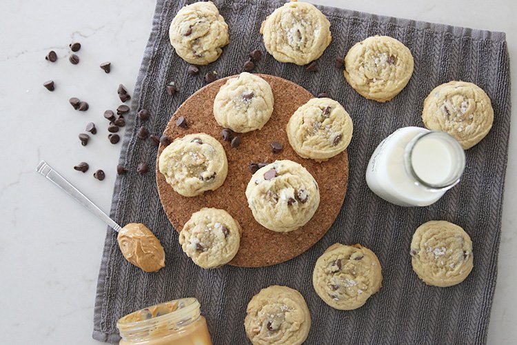 peanut butter chocolate chip cookies on a counter with a glass of milk