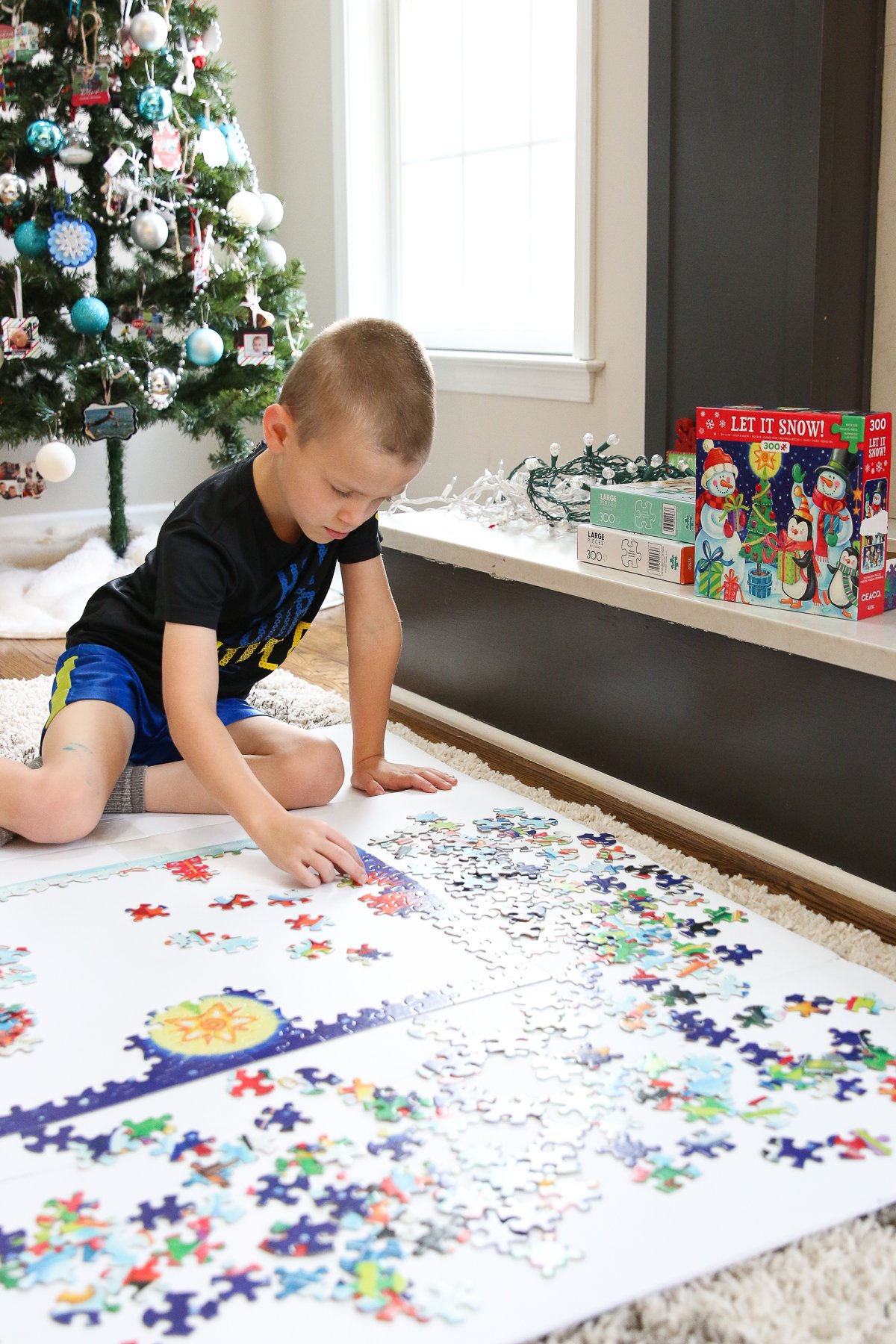 Boy putting a puzzle together on the carpet during Christmas time