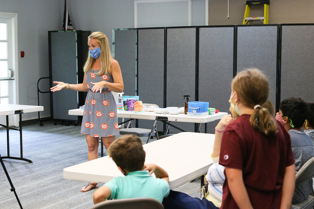 teacher standing in front of group teaching a class at a library