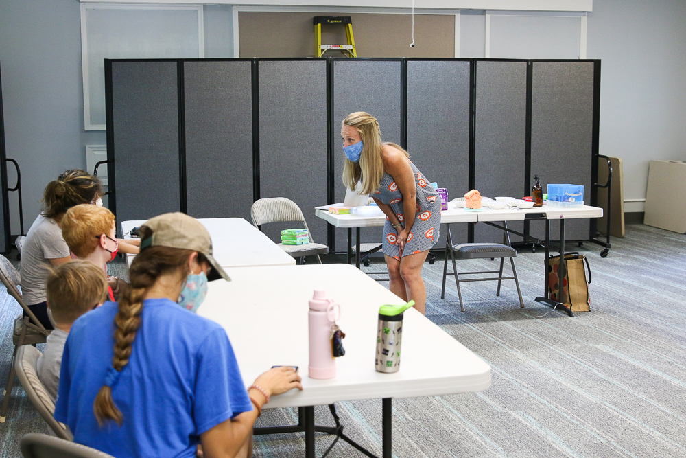 teacher standing in front of group teaching a class at a library