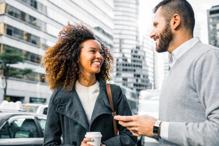 Facebook Marketplace safety: Two people having a conversation outdoors in a city setting.