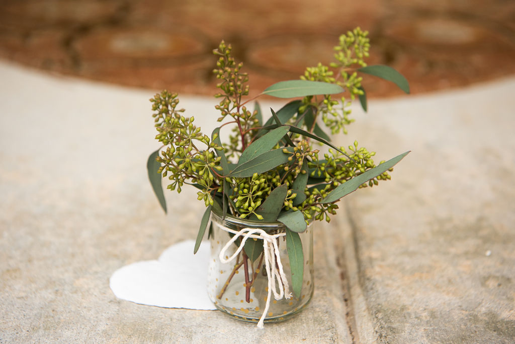 glass jar of small green springs on the ground