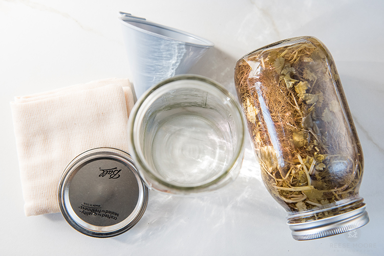 Tools needed to make DIY Scented Vinegar Cleanser - Mason Jar, Mason jar top, cheese cloth, funnel, and scented ingredients (e.g. herbs and fruit peels)