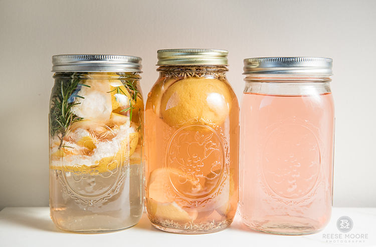 3 mason jars filled with DIY scented vinegar cleanser - grapefruit and rosemary, orange clove, and lemon lavender