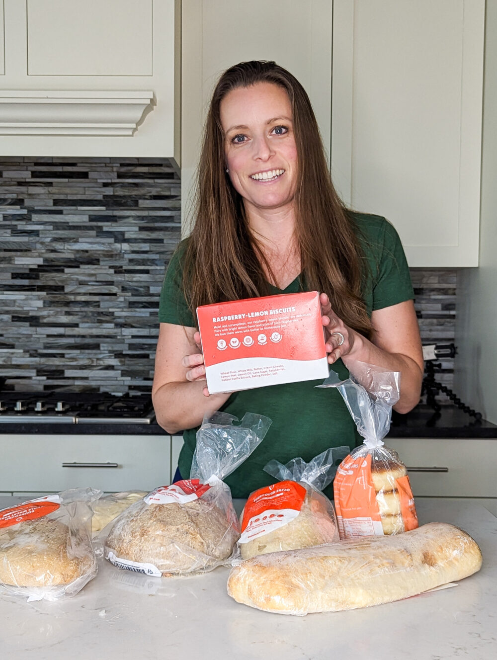 woman holding raspberry lemon biscuits from Wildgrain to share a Review of the Wildgrain Subscription Box